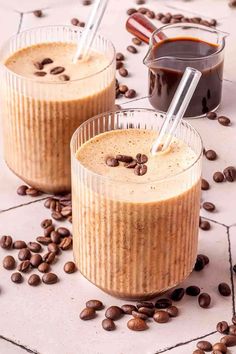 two glasses filled with coffee pudding on top of coffee beans