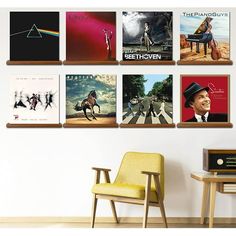 a wall mounted to the side of a white wall filled with pictures and music album covers