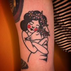 a woman holding a baby tattoo on her arm