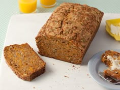 a loaf of bread sitting on top of a cutting board next to two slices of cake