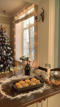 a christmas tree is decorated with lights and bake cookies in front of a window