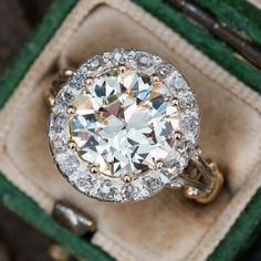 This magnificent late-Victorian ring contains one (1) round transitional brilliant cut diamond set with ten-prongs and bordered with a silver topped gold halo setting and accented with eighteen (18), bead set, old mine cut diamonds. The ring measures 15.2mm at the top, rises 6.5mm above the finger, tapering to 2.3mm wide and 1.1mm thick at the base of the shank. The ring is currently a size 6.25 and we offer complimentary resizing to fit. Gilded Era, Antique Cushion Cut Diamond, Faberge Jewelry, Emerald Ring Vintage, Victorian Ring, Halo Setting, Victorian Rings, Classic Engagement Rings, Garnet Jewelry