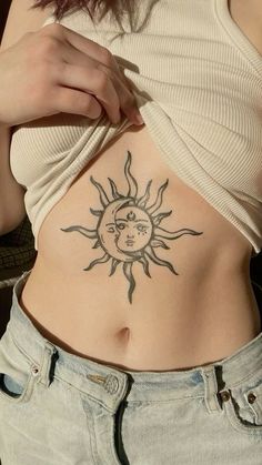 a woman with a sun and moon tattoo on her stomach