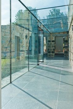 an empty walkway between two buildings with glass walls