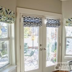 a living room filled with furniture and windows covered in roman blind shades on top of them