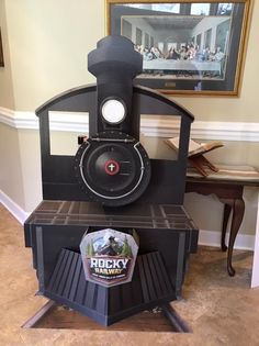 an old fashioned steam engine sitting on top of a wooden shelf in a living room