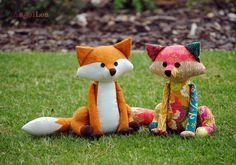 two stuffed animals are sitting in the grass