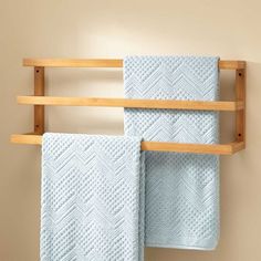 two towels are hanging on a wooden rack