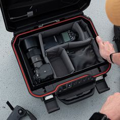 an open suitcase with cameras inside on the floor