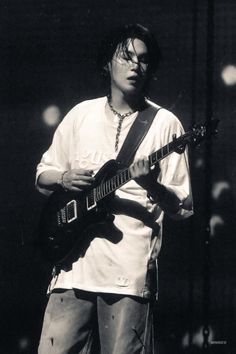 black and white photograph of a man playing an electric guitar