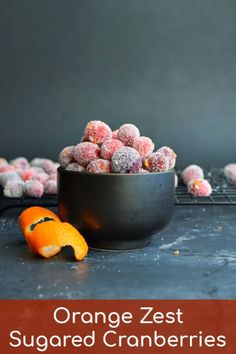 a bowl filled with powdered donuts next to an orange