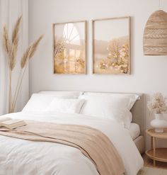 a bedroom with two paintings hanging above the bed