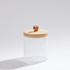 an empty glass jar with a wooden lid