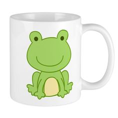 a green frog sitting on top of a white mug