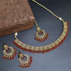 Indulge in the rich elegance of our Red Color Indian Bollywood Jewelry Set, a timeless embodiment of grace and allure. This captivating ensemble, comprising an exquisite choker necklace, coordinating earrings, and a delicate tikka, seamlessly weaves traditional opulence with contemporary sophistication.  Crafted with meticulous attention to detail, each piece showcases intricate craftsmanship and a fusion of cultural heritage with modern aesthetics. The necklace drapes gracefully along your neck Festive Jewelry Sets With Elegant Design For Party, Hand Set Metal Bridal Necklace For Party, Festive Metal Bridal Necklace For Party, Red Indian, Bollywood Jewelry, Engagement Party Wedding, Indian Bollywood, Brass Necklace, Pin Jewelry