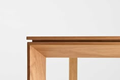 a close up of a wooden table with a white wall in the background