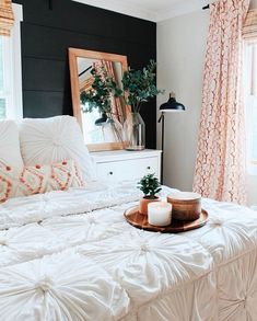 a bed with white sheets and pillows in front of a mirror on top of a dresser