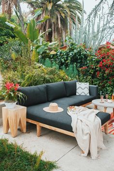 a couch and table in front of some plants