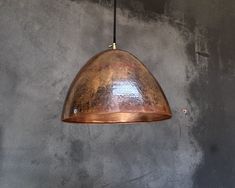 a copper colored light hanging from a ceiling