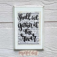 a framed print with the words, small we gather at the river in black ink