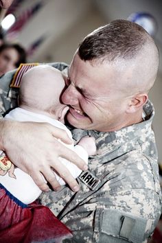 a soldier holding a baby in his arms