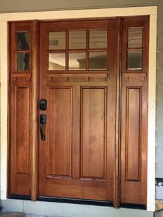 the front door is made of wood and has two glass panels on each paneling