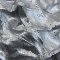 the fabric is shiny and silver with black spots