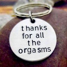 a keychain that says thanks for all the orgasms on it, sitting on top of a rock