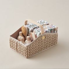 a basket filled with lots of items on top of a white table next to a wall