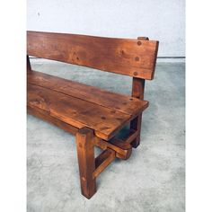 a wooden bench sitting on top of a cement floor