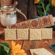 some cookies are sitting on a table next to a mason jar and sunflowers