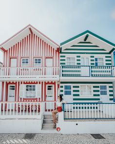 three houses painted in different colors on the side of each other with balconies