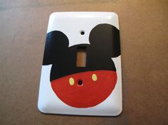 a mickey mouse light switch plate cover on a table with a black and white background