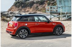 a red mini cooper parked on the beach