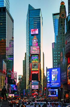 a busy city street filled with lots of tall buildings and neon signs on the side of it