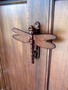 a close up of a door handle with a dragonfly on it's side