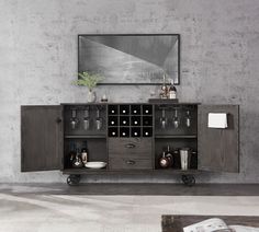 an entertainment center with wine glasses and bottles on wheels in front of a concrete wall