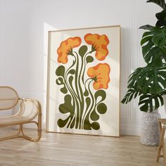 an orange and green flower print on a white wall next to a wicker chair