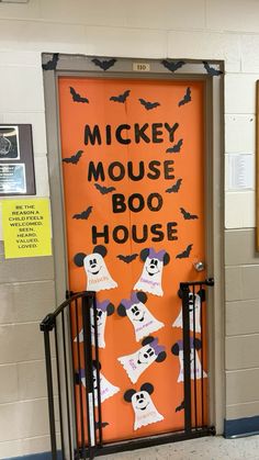 an orange door decorated with halloween decorations and words that read, mickey mouse boo house