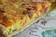 a slice of quiche sitting on top of a glass tablecloth covered placemat