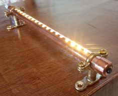 a close up of a metal object on a wooden table with light coming from it