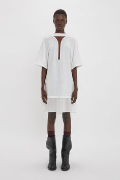 Featured on the SS24 runway, the Frame Cut-Out T-Shirt Dress deconstructs an everyday wardrobe staple for an elevated reimagining of the simple T-shirt dress. Designed in bonded linen jersey with a contrasting silk crepe panel, it has drop shoulders and a boyish, oversized fit. A sexy, navel-grazing keyhole neckline and cut-out detail at the back of the neck add feminine counterpoints to the utilitarian aesthetic. Styled with the Superfine Rib Socks Victoria Beckham Frame Cut-Out T-Shirt Dress I Utilitarian Aesthetic, White Tshirt Dress, Size 12 Uk, Simple T Shirt, Runway Dresses, Keyhole Neckline, Simple Tshirt, Silk Crepe, Everyday Wardrobe