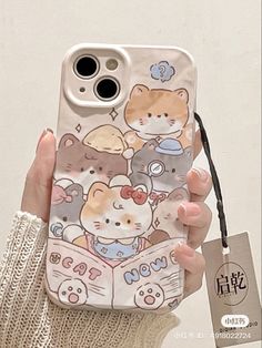 a person holding up a phone case with cats on it