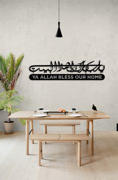 a wooden table sitting in front of a white wall with a sign that says ya'allah blessing our home