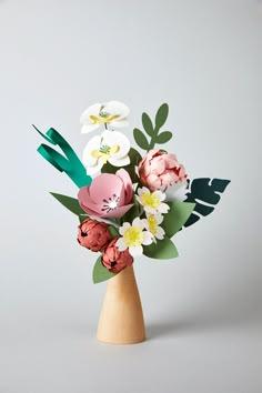 a wooden vase filled with paper flowers on top of a table