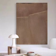 a living room with white furniture and a large painting on the wall above the coffee table