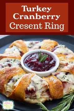 turkey cranberry crescent ring on a blue plate with rosemary garnish in the middle