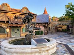 a fountain in front of a building with a sign on it that says, the castle is