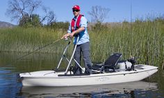 a man in a white kayak holding a fishing pole and standing on the water