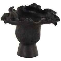 a black vase with flowers in it on a white background